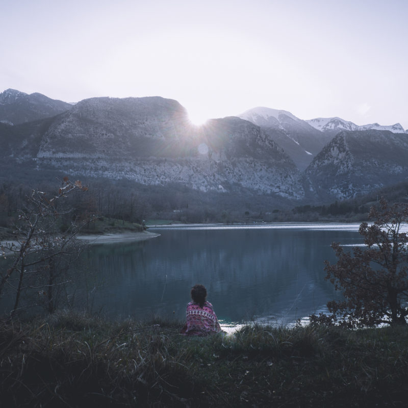 Ragazza al tramonto tra le montagne al lago di castel san vincenzo